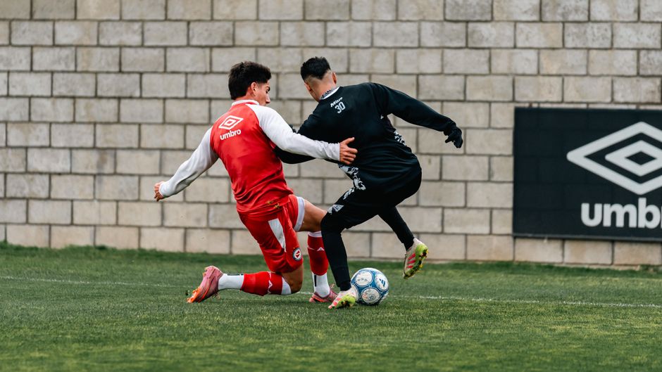Two soccer players in a competitive tackle during a match, showcasing athleticism and team sports.
